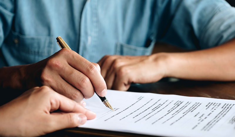 man signing an agreement_Canva-png